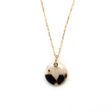 エシカルでサステナブルなジュエリーを提案するHASUNAの、ウィルクス貝とダイヤモンドを使用したネックレス。パーツ、チェーンはすべてK18製。直径約1㎝の円形のウィルクスを使用。ウィルクスはダルメシアン柄のような模様がもともと入ったシェルです。このウィルクスの上部に、ストーンを金でぐるりと一周巻くような石座に留めた、直径約1mm(0.005ct)のメレダイヤモンドをあしらいました。このダイヤモンドの留まったところからK18の細い線によるバチカンがはじまり、ネックレスチェーンを通しています。HAUSNA エシカル サステナブル エシカルジュエリーHASUNA