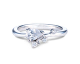 婚約指輪 エンゲージメントリング ブライダルリング ブランド HASUNA エシカルジュエリー
中央のセンターストーンは、約6mm×4mm程度の雫型のダイヤモンド。先端が少し上を向く程度に横たわらせた角度に配置し、先端はV字の爪、一番張り出した部分を丸爪で留めている。腕は雫型のダイヤの左端からゆるやかなS字を描いて指に巻き付くように正面へ戻り、雫型のダイヤの下に設置します。腕の先端には約2mmのメレダイヤ、約1mm空けて1.5mmのメレダイヤ、その斜め上、腕の上側側面に1.5mmのメレダイヤが留まっています。